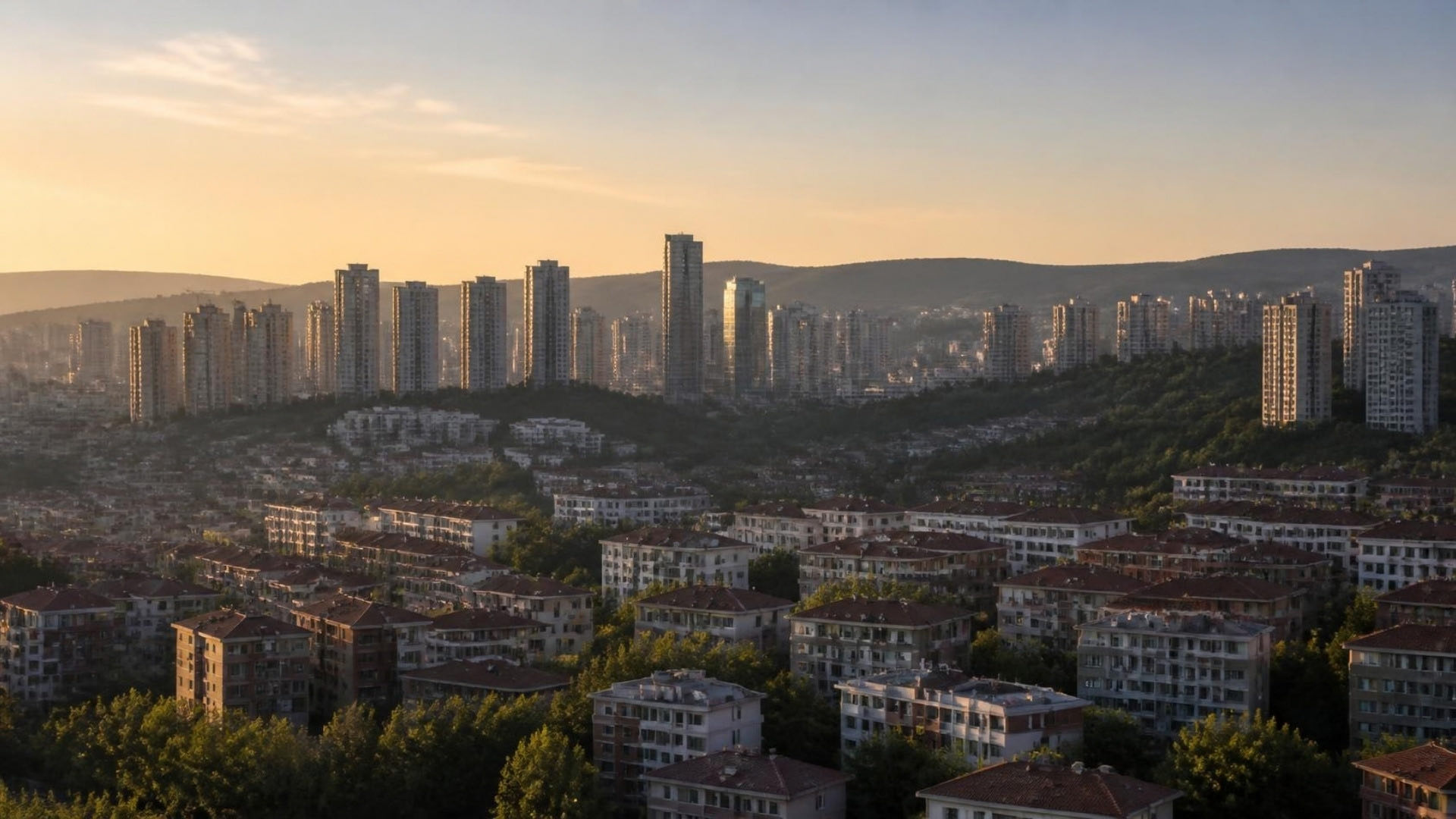 Modern apartment and office towers rising over green hills at golden hour on Istanbul’s Anatolian side